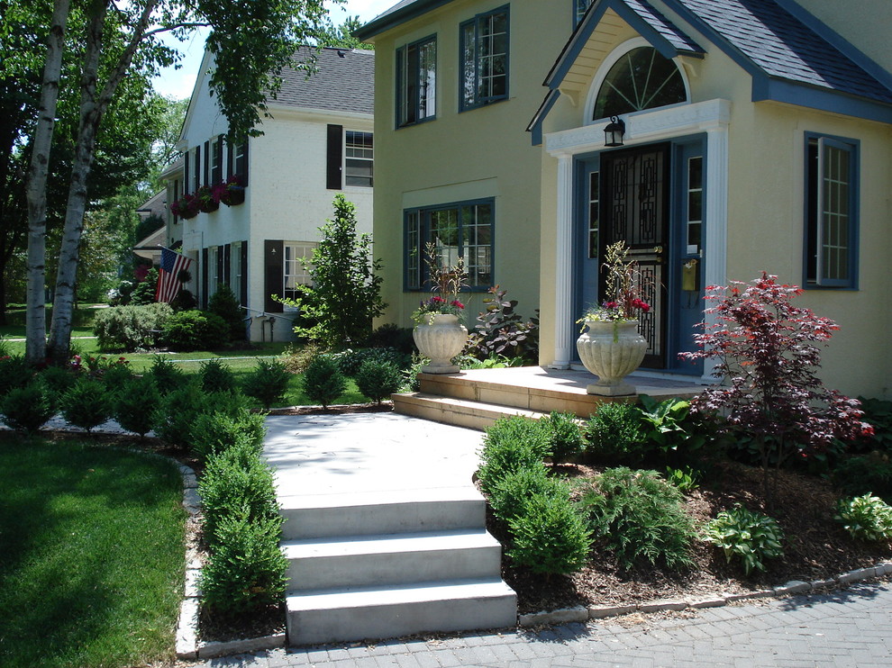 This is an example of a mid-sized traditional front yard partial sun garden in Minneapolis with concrete pavers.