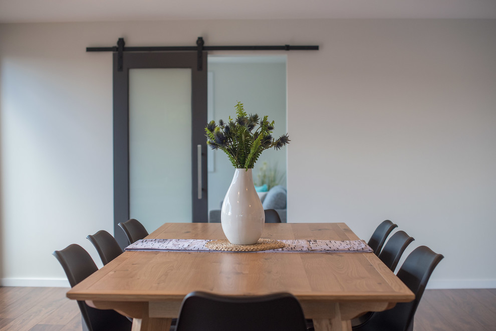 Photo of a large contemporary dining room in Hobart with white walls, medium hardwood floors and brown floor.