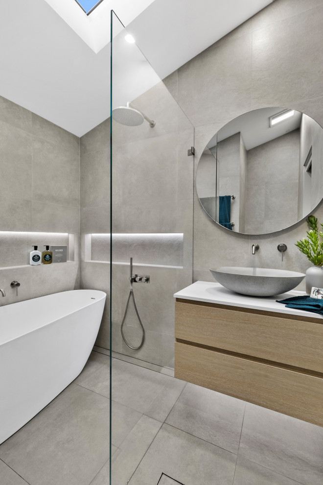 Contemporary bathroom in Sydney with flat-panel cabinets, light wood cabinets, a freestanding tub, gray tile, a vessel sink, grey floor, white benchtops, a niche, a single vanity, a floating vanity, vaulted and an open shower.