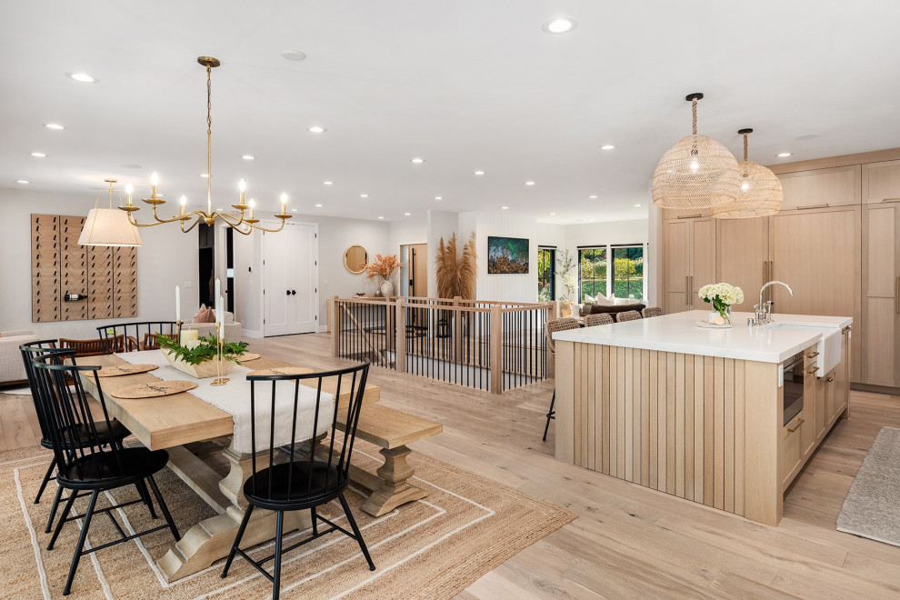 Geräumige Moderne Wohnküche ohne Kamin mit weißer Wandfarbe, hellem Holzboden, Kaminumrandung aus Beton, buntem Boden, gewölbter Decke und Holzwänden in Seattle