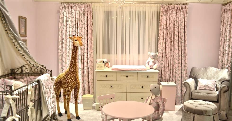 Photo of a traditional nursery for girls in Los Angeles with pink walls.