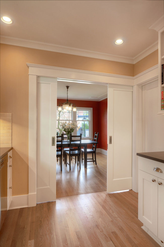 Photo of a mid-sized arts and crafts separate dining room in Seattle with red walls and medium hardwood floors.