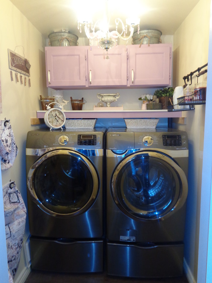 Small transitional single-wall dedicated laundry room in Toronto with recessed-panel cabinets, yellow walls, vinyl floors and a side-by-side washer and dryer.