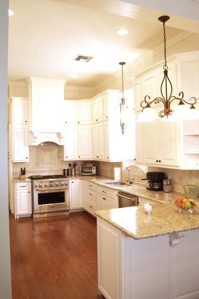 This is an example of a traditional kitchen in New Orleans with stainless steel appliances and travertine splashback.