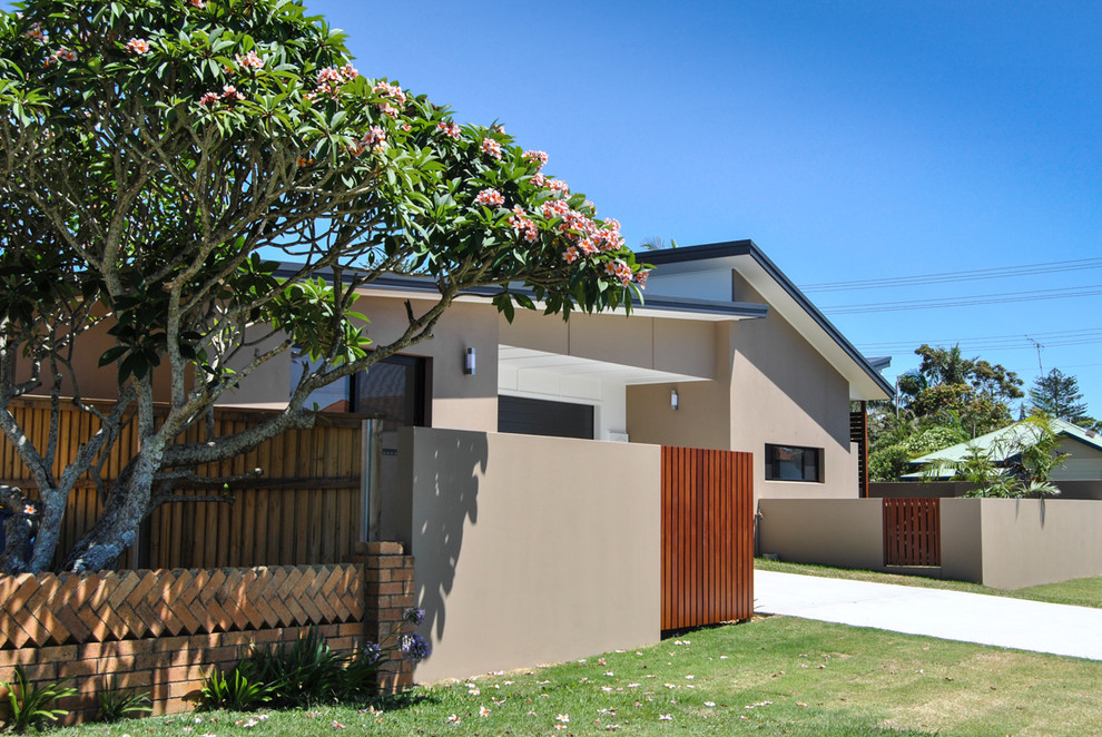 This is an example of a mid-sized contemporary one-storey stucco brown exterior in Other with a shed roof.
