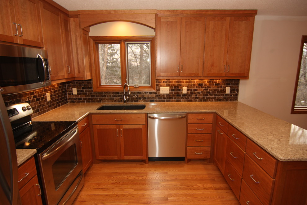 Mid-sized elegant u-shaped medium tone wood floor open concept kitchen photo in Minneapolis with an undermount sink, shaker cabinets, red cabinets, quartz countertops, brown backsplash, stone tile backsplash, stainless steel appliances and a peninsula