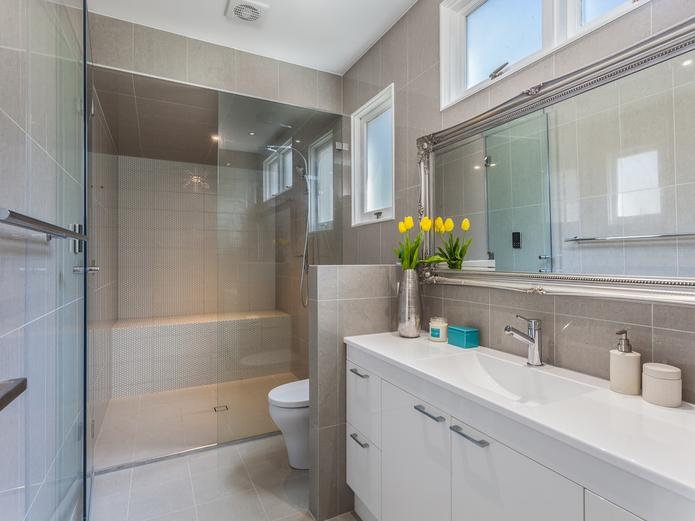This is an example of a mid-sized modern bathroom in Brisbane with a sauna, a one-piece toilet, gray tile, porcelain tile, grey walls, porcelain floors and with a sauna.