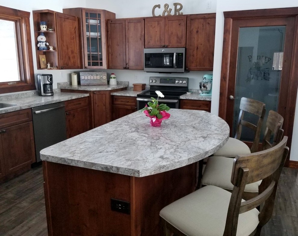 Example of a transitional u-shaped kitchen design with an undermount sink, shaker cabinets, laminate countertops, stainless steel appliances and an island