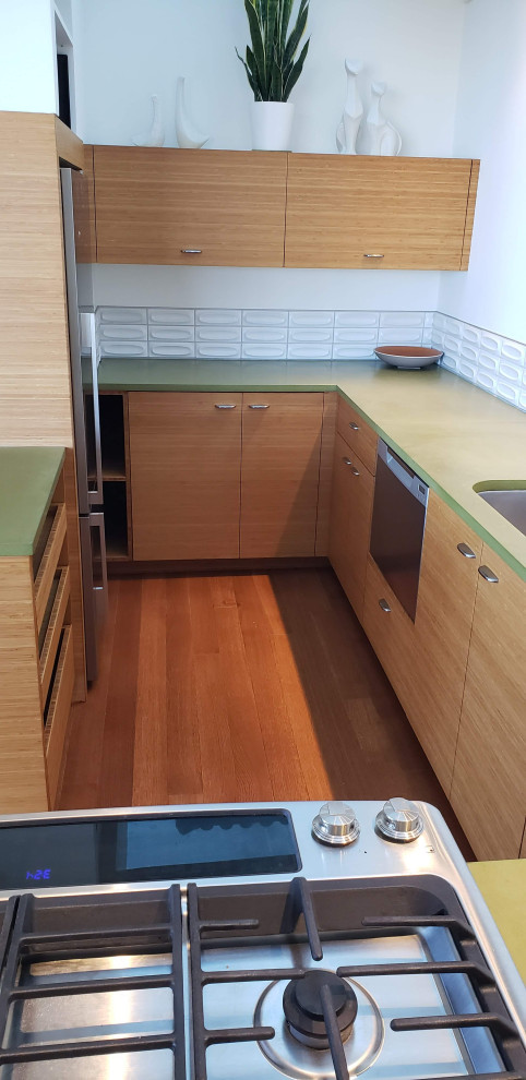 Design ideas for a small midcentury l-shaped open plan kitchen in San Francisco with an undermount sink, flat-panel cabinets, medium wood cabinets, concrete benchtops, white splashback, subway tile splashback, stainless steel appliances, medium hardwood floors, a peninsula, brown floor, green benchtop and exposed beam.
