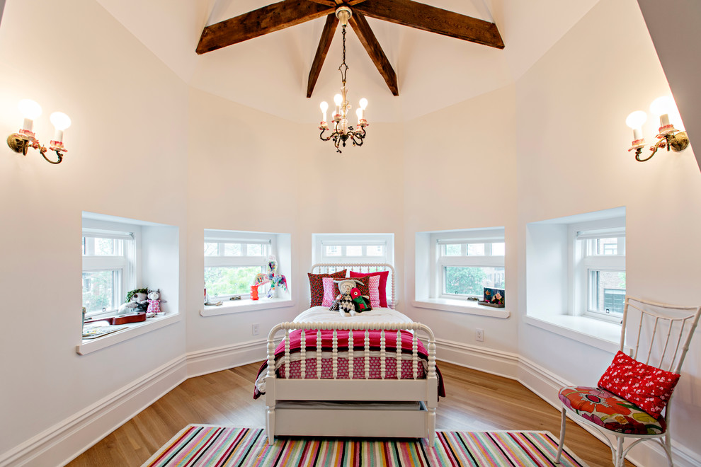 This is an example of an expansive transitional kids' room for girls in New York with light hardwood floors and beige walls.