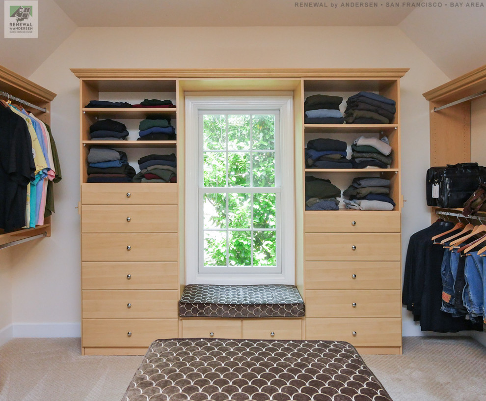 Photo of a large men's walk-in wardrobe in San Francisco with light wood cabinets, carpet, beige floor and vaulted.