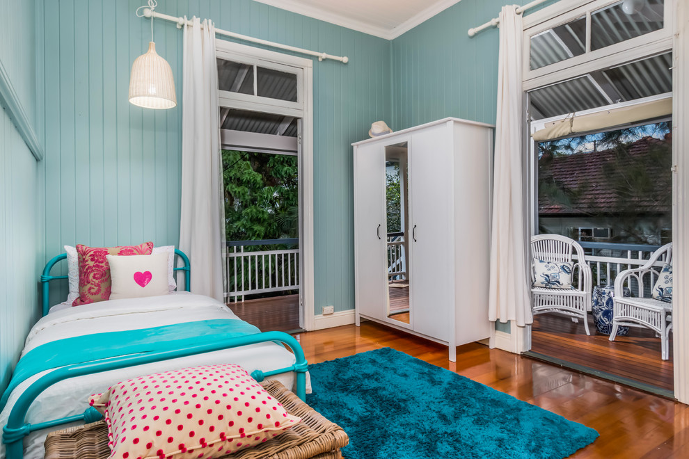Photo of a mid-sized beach style kids' room for girls in Brisbane with blue walls and medium hardwood floors.