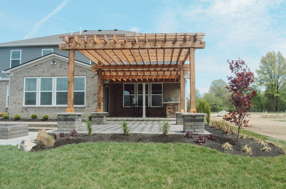 Example of a small mountain style backyard concrete paver patio design in Indianapolis with a fire pit and a pergola
