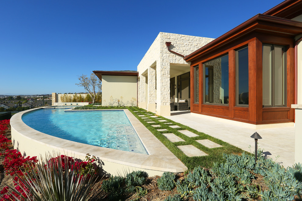 Example of a backyard custom-shaped hot tub design in Orange County