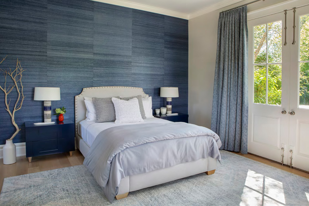This is an example of a transitional guest bedroom in New York with blue walls, light hardwood floors and beige floor.