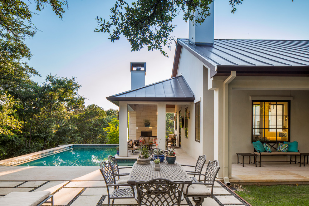 This is an example of a transitional backyard l-shaped pool in Austin with a pool house and natural stone pavers.