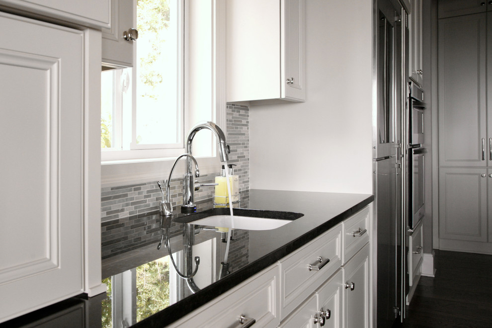 Large transitional l-shaped dark wood floor eat-in kitchen photo in Atlanta with an undermount sink, recessed-panel cabinets, white cabinets, granite countertops, gray backsplash, mosaic tile backsplash, stainless steel appliances and an island
