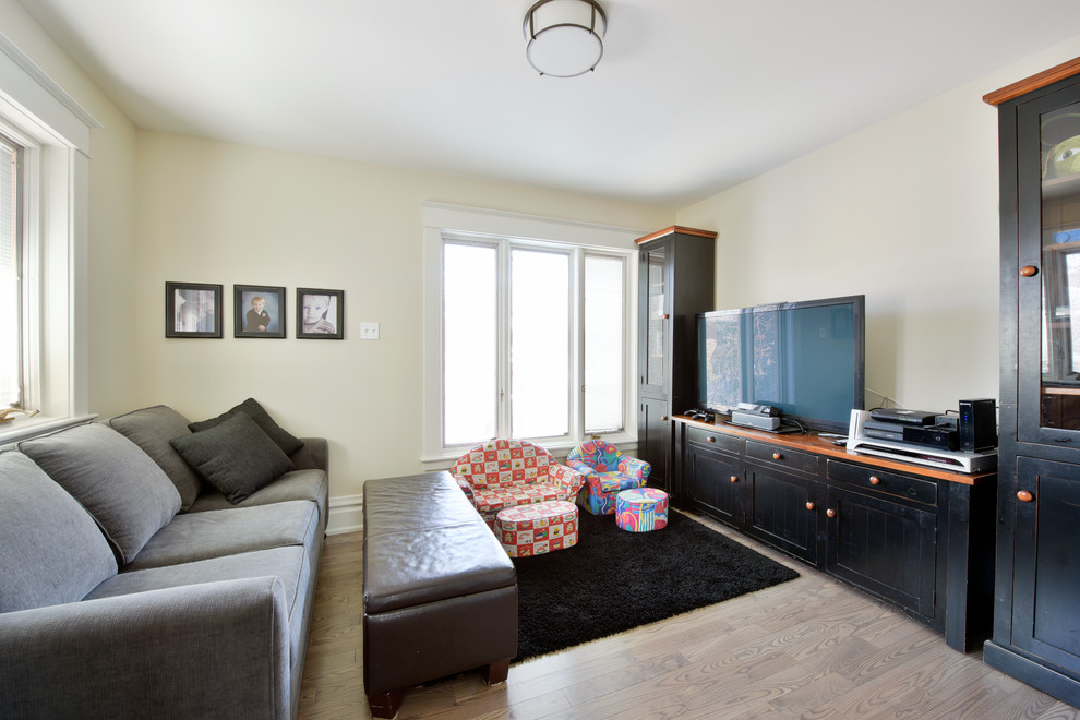 Photo of a mid-sized transitional gender-neutral kids' playroom in Ottawa with beige walls and light hardwood floors.