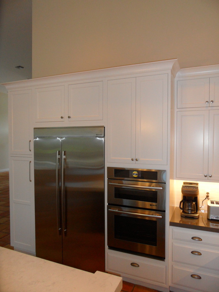 Large transitional l-shaped eat-in kitchen photo in Miami with an undermount sink, shaker cabinets, white cabinets, quartz countertops, white backsplash, ceramic backsplash, stainless steel appliances and an island