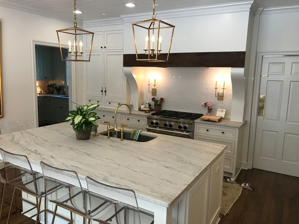Inspiration for a large transitional u-shaped dark wood floor and brown floor eat-in kitchen remodel with an undermount sink, recessed-panel cabinets, white cabinets, marble countertops, white backsplash, subway tile backsplash, stainless steel appliances, an island and white countertops