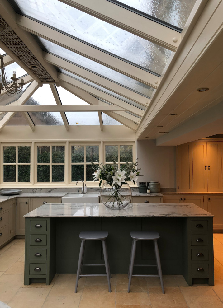 Photo of a medium sized traditional l-shaped kitchen in Surrey with flat-panel cabinets, quartz worktops, an island and white worktops.