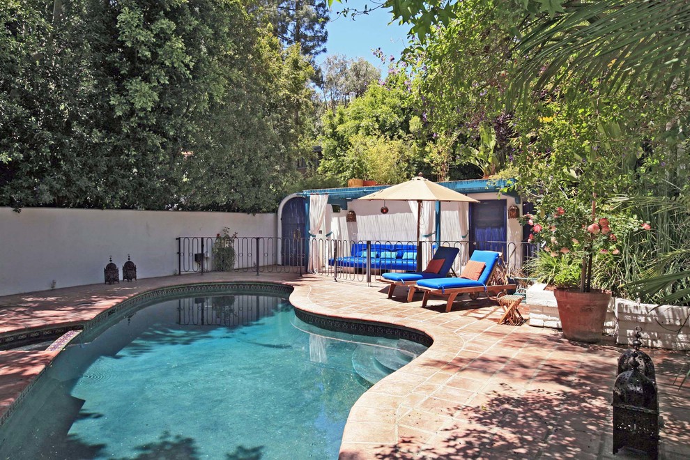 Mid-sized mediterranean backyard custom-shaped lap pool in Los Angeles with tile.
