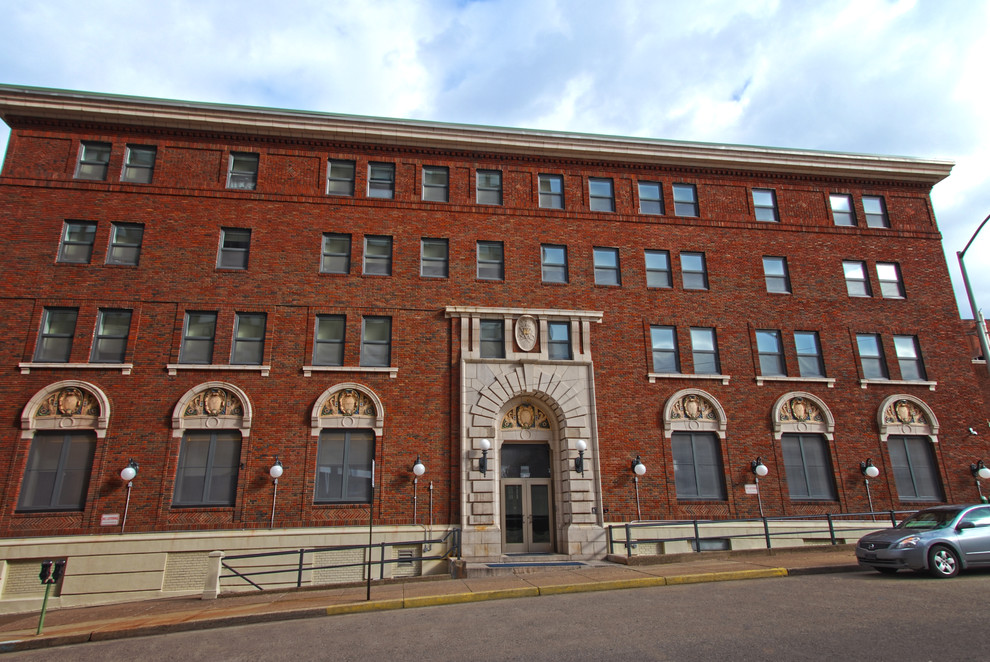 Expansive industrial three-storey brick red apartment exterior in Denver with a flat roof.