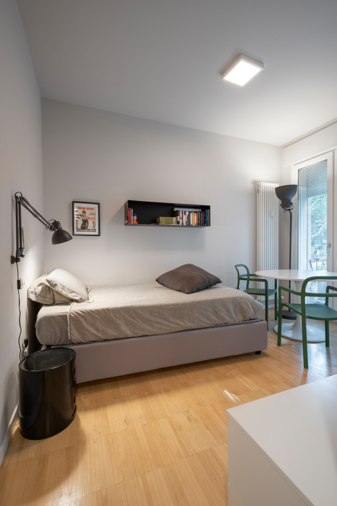 На фото: маленькая спальня в современном стиле с белыми стенами и деревянным полом для на участке и в саду