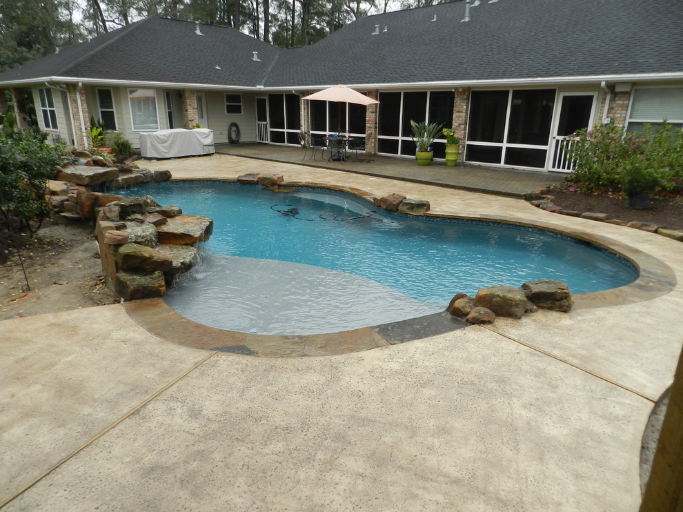 Design ideas for a mid-sized country backyard custom-shaped natural pool in Houston with stamped concrete.