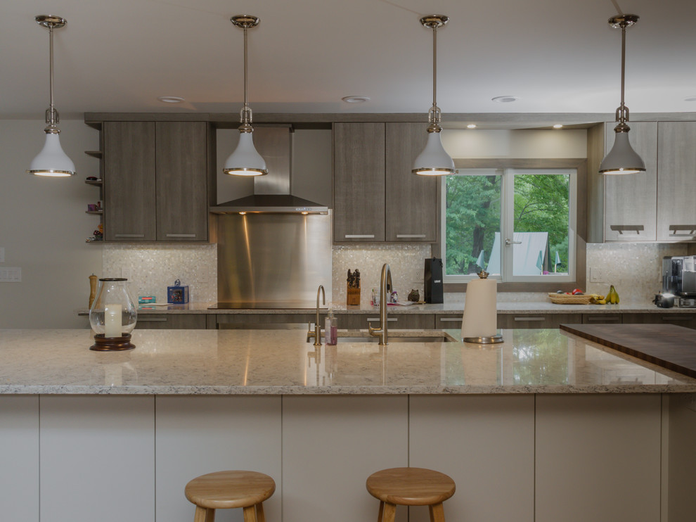 This is an example of a large modern l-shaped eat-in kitchen in New York with an undermount sink, flat-panel cabinets, light wood cabinets, quartz benchtops, white splashback, mosaic tile splashback, stainless steel appliances, medium hardwood floors and with island.