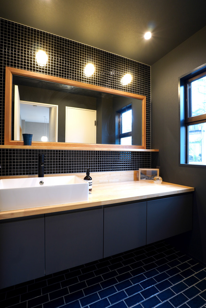 Idéer för att renovera ett toalett, med släta luckor, grå skåp, svart kakel, mosaik, svarta väggar, klinkergolv i keramik, ett fristående handfat, laminatbänkskiva och svart golv