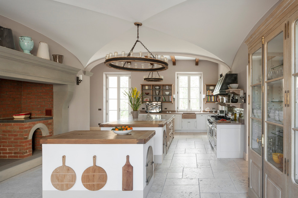 Inspiration for a large country u-shaped eat-in kitchen in London with light wood cabinets, marble benchtops, green splashback, subway tile splashback, stainless steel appliances, limestone floors and multiple islands.