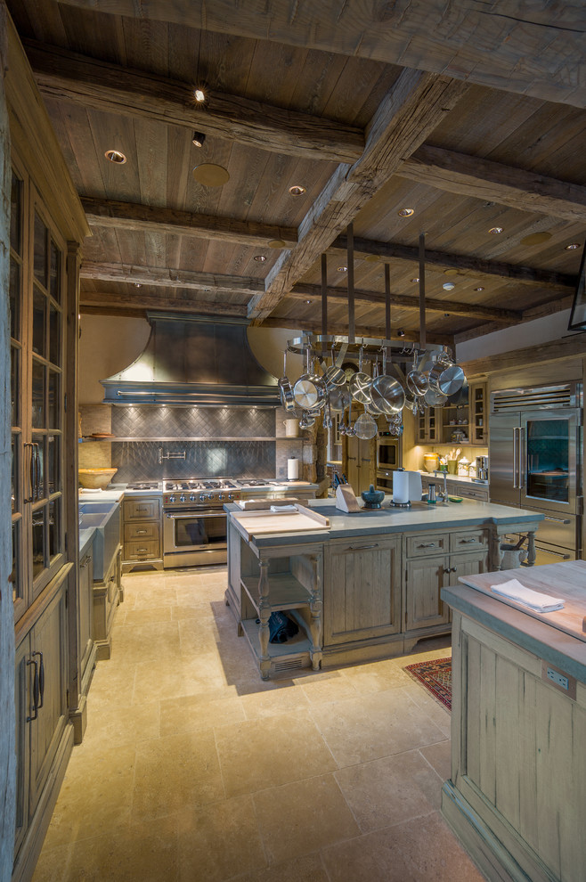 Design ideas for a large country galley open plan kitchen in Charlotte with a farmhouse sink, glass-front cabinets, distressed cabinets, limestone benchtops, porcelain splashback, stainless steel appliances and multiple islands.
