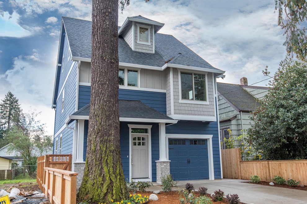 Photo of a large arts and crafts three-storey blue exterior in Portland with wood siding and a gable roof.
