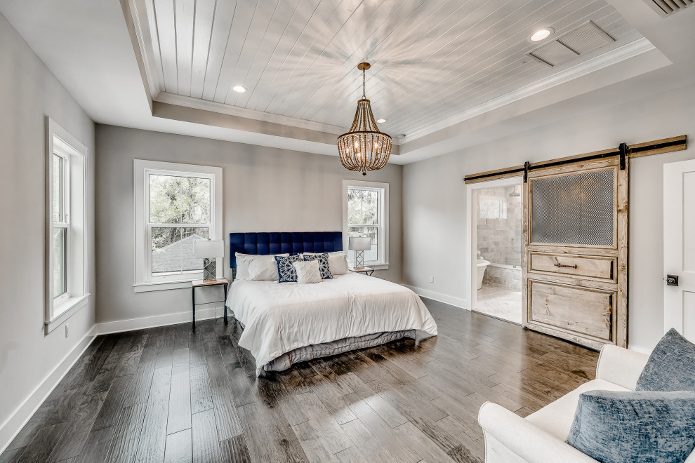 Design ideas for a mid-sized country master bedroom in Jacksonville with grey walls, medium hardwood floors and brown floor.