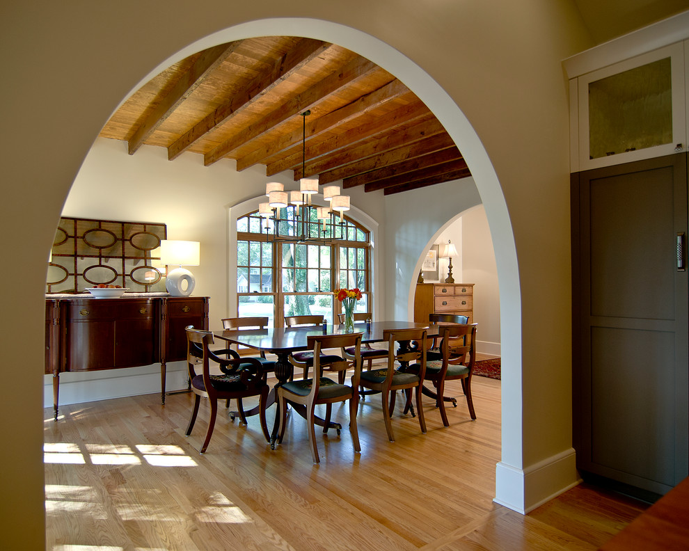 Inspiration for a large mediterranean separate dining room in Charlotte with white walls, light hardwood floors, no fireplace and brown floor.