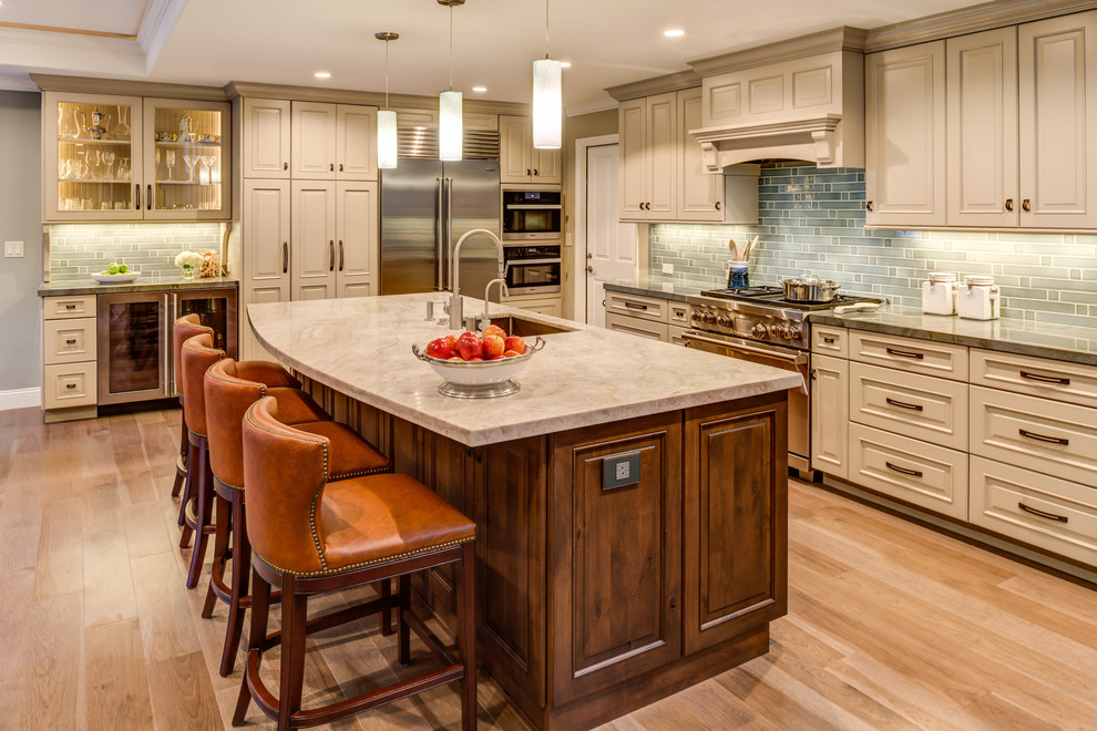 Mid-sized traditional l-shaped open plan kitchen in San Francisco with a drop-in sink, raised-panel cabinets, white cabinets, quartz benchtops, blue splashback, ceramic splashback, stainless steel appliances, light hardwood floors, with island and beige floor.