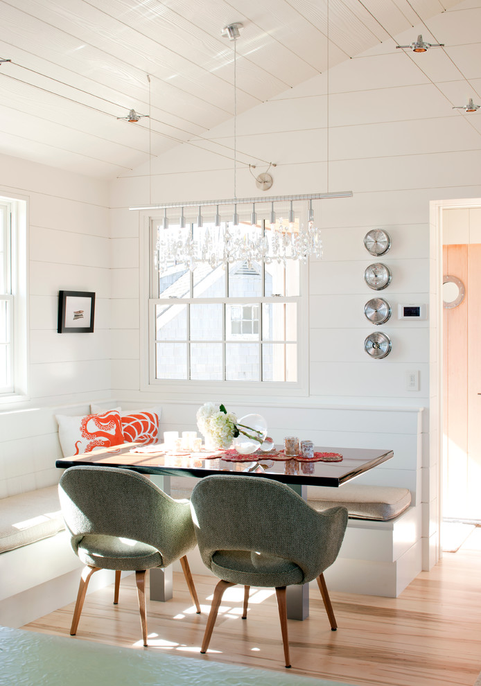 Beach style dining room in Boston with white walls and medium hardwood floors.