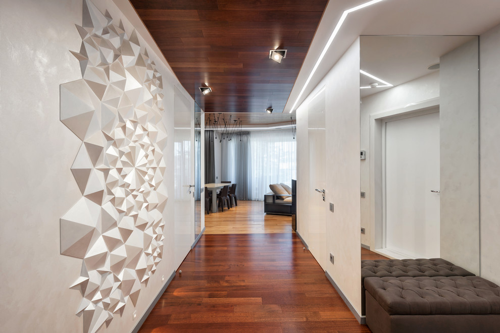 This is an example of a large contemporary hallway in Moscow with white walls, dark hardwood floors and brown floor.