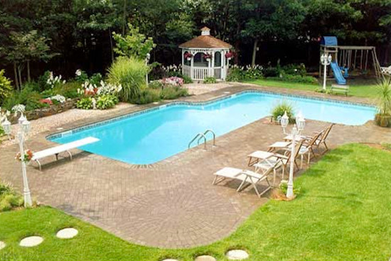 Backyard stone and custom-shaped pool photo