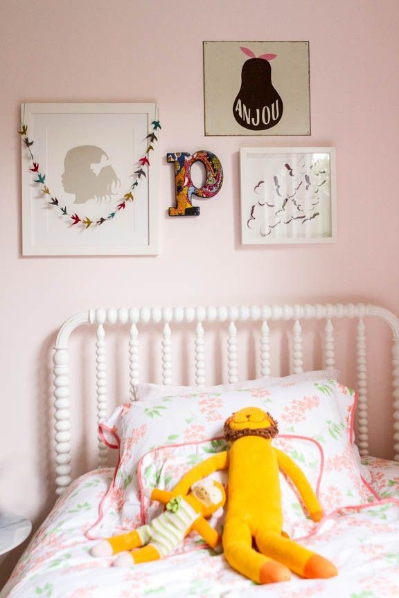 Photo of a small eclectic kids' bedroom for kids 4-10 years old and girls in New York with pink walls and dark hardwood floors.