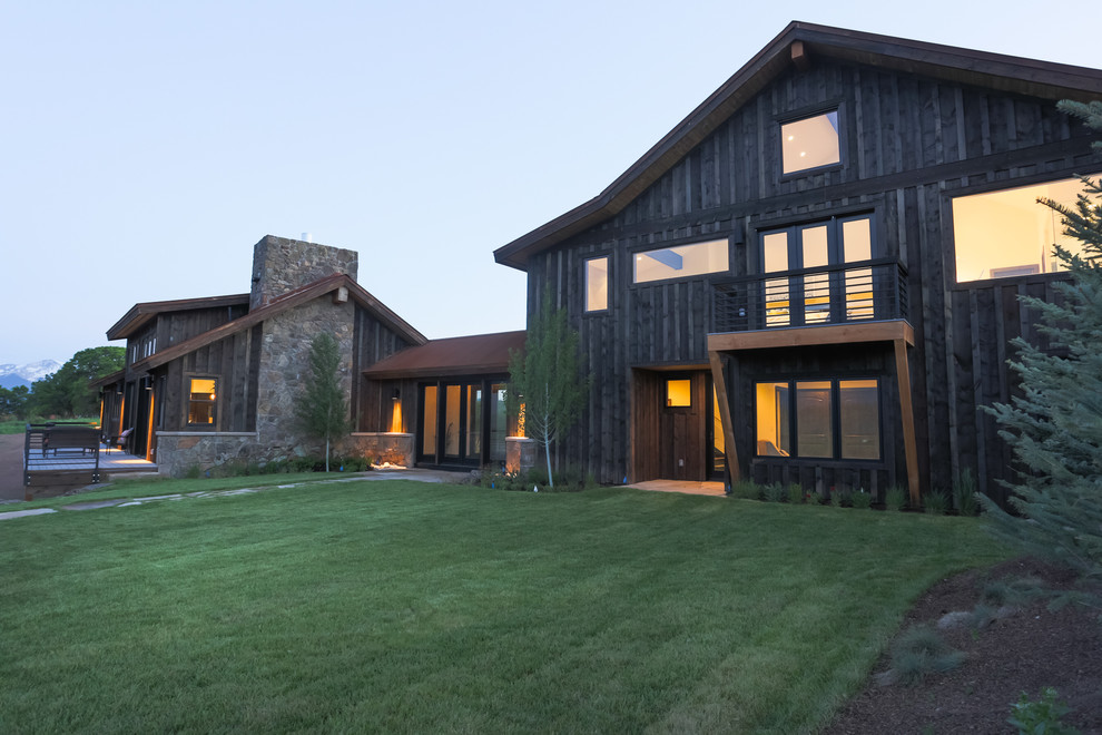 Photo of an expansive contemporary two-storey black exterior in Denver with wood siding.