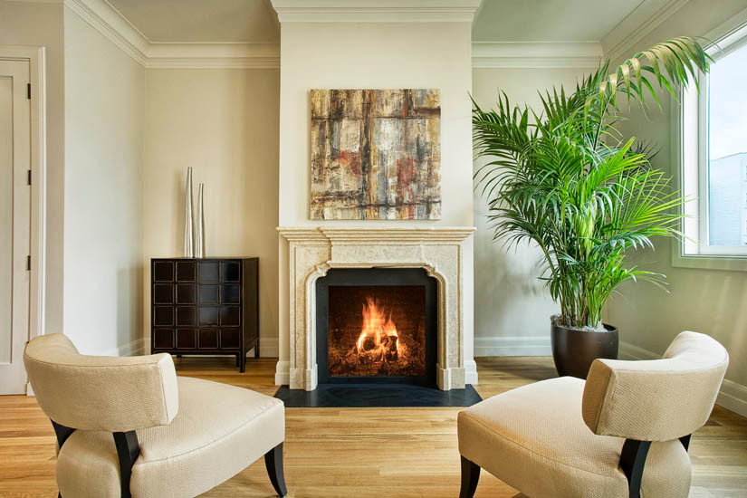 Design ideas for a mid-sized traditional enclosed family room in San Francisco with beige walls, light hardwood floors, a standard fireplace and a stone fireplace surround.