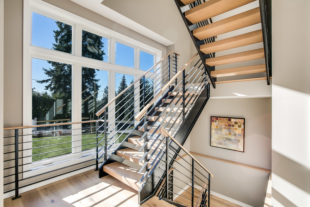 Inspiration for a mid-sized contemporary wood floating staircase in Seattle with open risers and metal railing.