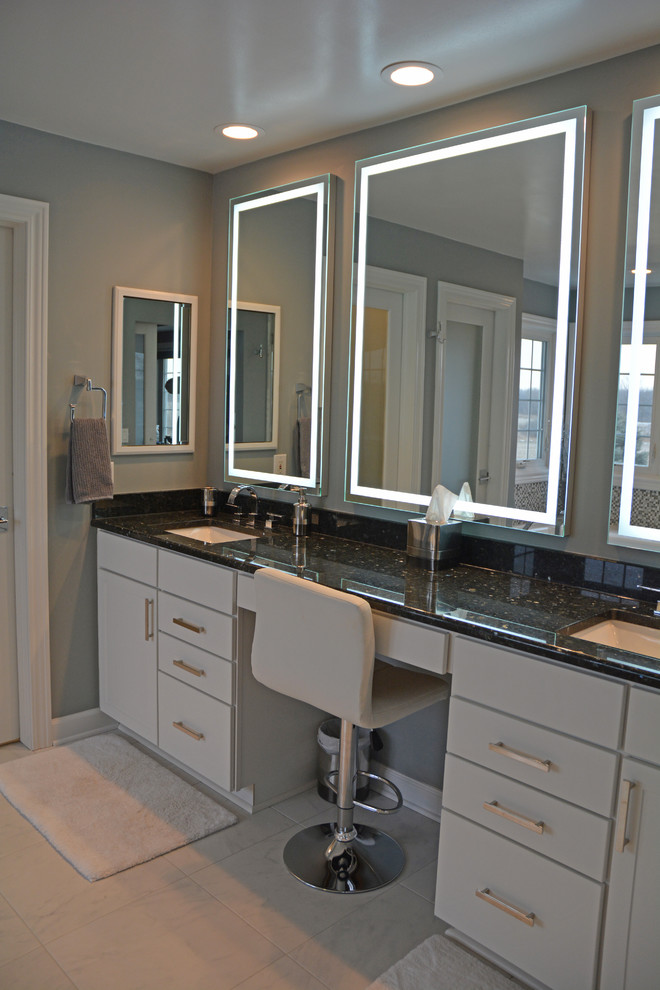 Photo of a large contemporary master bathroom in Other with flat-panel cabinets, white cabinets, a drop-in tub, a corner shower, a bidet, multi-coloured tile, mosaic tile, grey walls, porcelain floors, an undermount sink, granite benchtops, white floor, a hinged shower door and black benchtops.