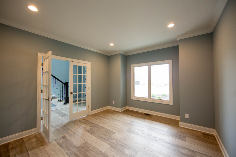 This is an example of a medium sized traditional home office in Indianapolis with blue walls, laminate floors, a freestanding desk and brown floors.