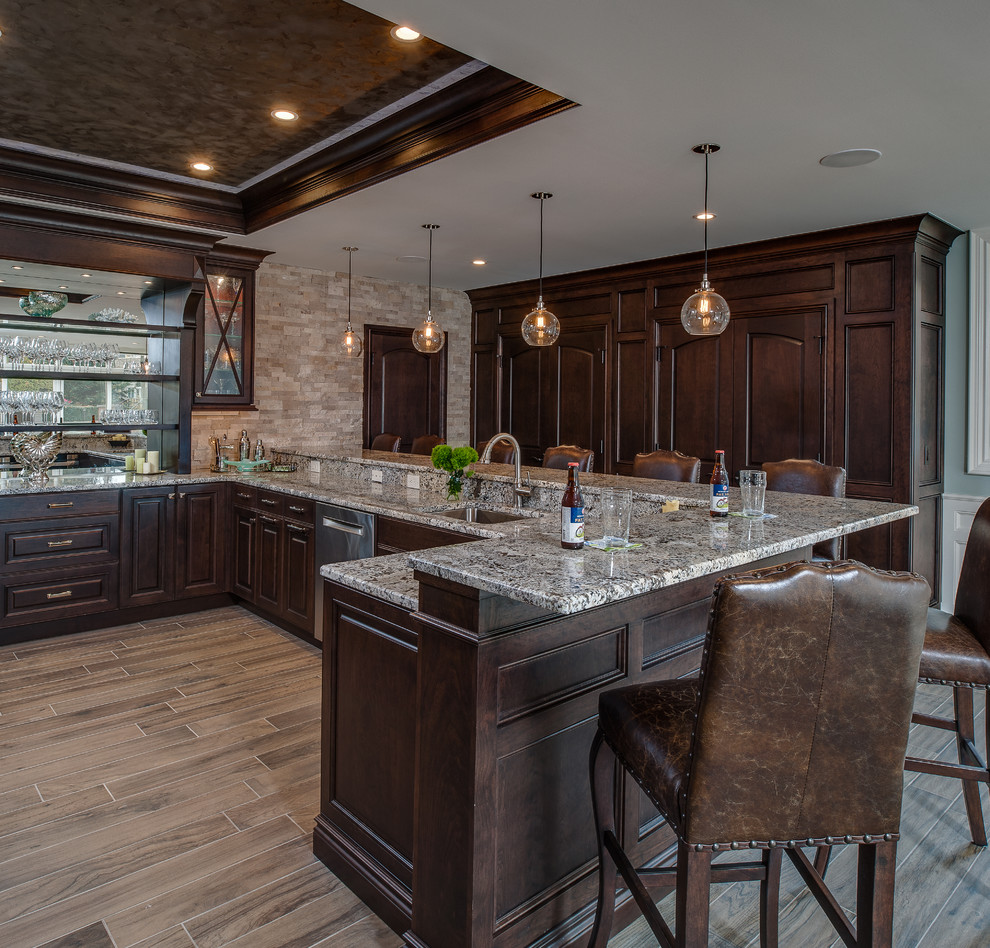 Design ideas for a large transitional u-shaped seated home bar in Detroit with an undermount sink, raised-panel cabinets, dark wood cabinets, quartz benchtops, porcelain floors and mirror splashback.