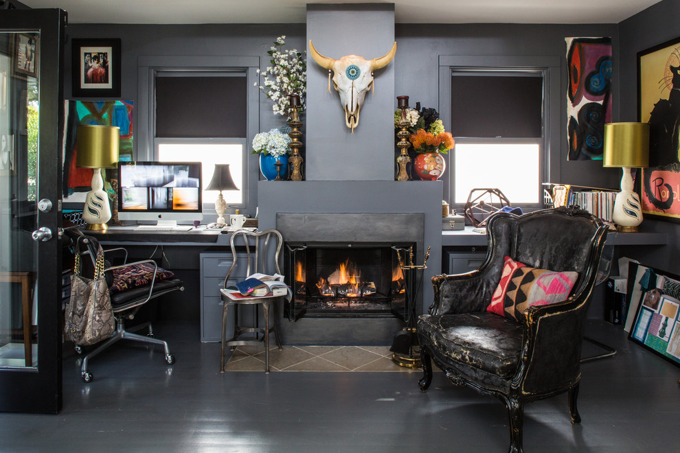 Mid-sized eclectic study room in Los Angeles with grey walls, painted wood floors, a standard fireplace, a built-in desk and a plaster fireplace surround.