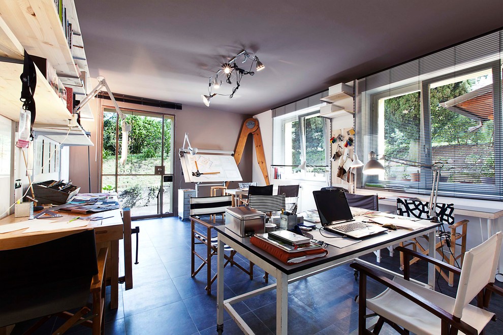 This is an example of an expansive contemporary study room in Venice with grey walls, porcelain floors and a freestanding desk.