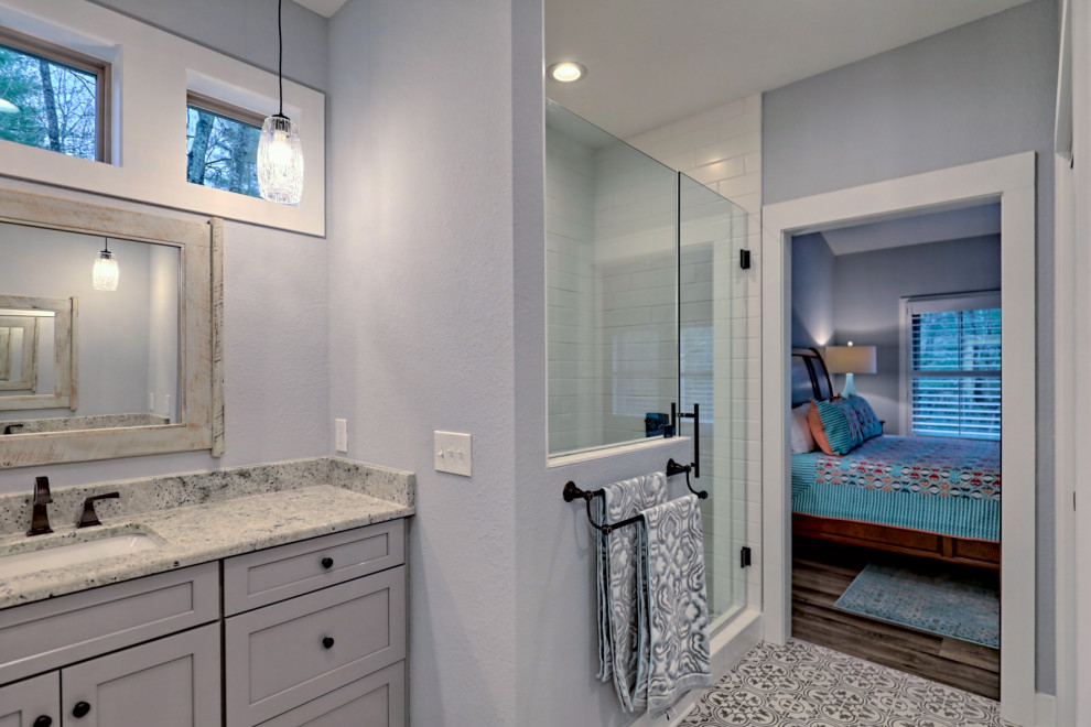 Photo of a large arts and crafts master bathroom in Atlanta with shaker cabinets, grey cabinets, an alcove shower, a two-piece toilet, grey walls, an undermount sink, granite benchtops, grey floor, a hinged shower door, white benchtops, an enclosed toilet, a double vanity, a built-in vanity and ceramic floors.